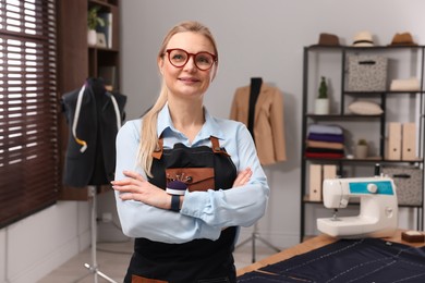 Photo of Portrait of professional dressmaker in apron at workshop