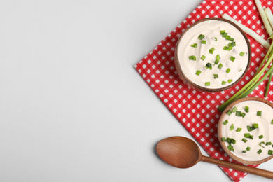 Fresh sour cream with onion on white table, flat lay. Space for text