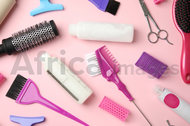 Professional tools for hair dyeing on pink background, flat lay