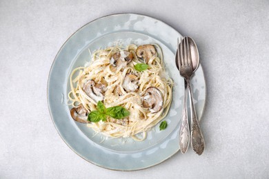 Photo of Delicious pasta with mushrooms on light grey table, top view