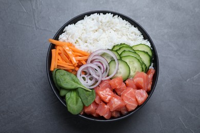 Delicious poke bowl with salmon and vegetables on grey table, top view