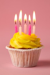 Tasty birthday cupcake with many candles on pink background, closeup