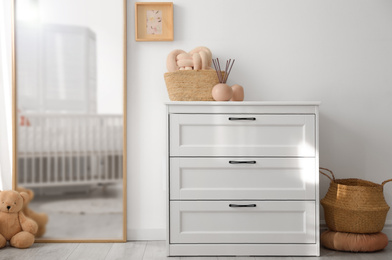 Beautiful nursery interior with white chest of drawers