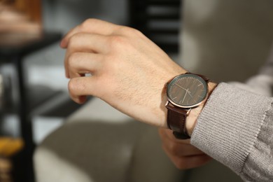 Man with luxury wrist watch indoors, closeup