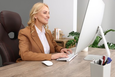 Photo of Lady boss working on computer at desk in office. Successful businesswoman