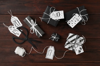 Photo of Flat lay composition with gift boxes on wooden table. Creating advent calendar