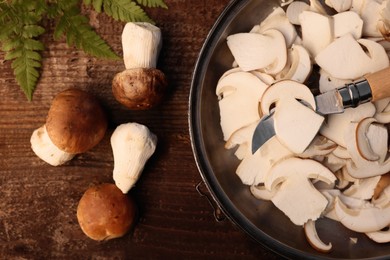 Flat lay composition with mushrooms and knife on wooden table