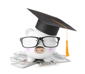 Money bills and piggy bank with glasses in graduation hat isolated on white