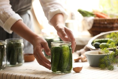 Photo of Woman canning cucumbers in kitchen, closeup view