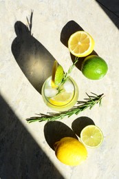 Photo of Tasty refreshing lemonade and ingredients on light grey table, flat lay. Summer drink