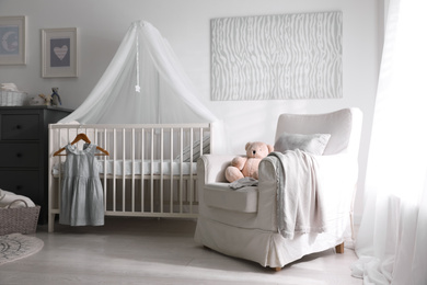 Baby room interior with comfortable crib and armchair