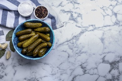 Bowl of pickled cucumbers and ingredients on white marble table, flat lay. Space for text