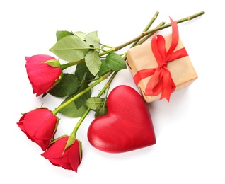 Beautiful gift box, roses and red heart on white background, top view. Valentine's day celebration