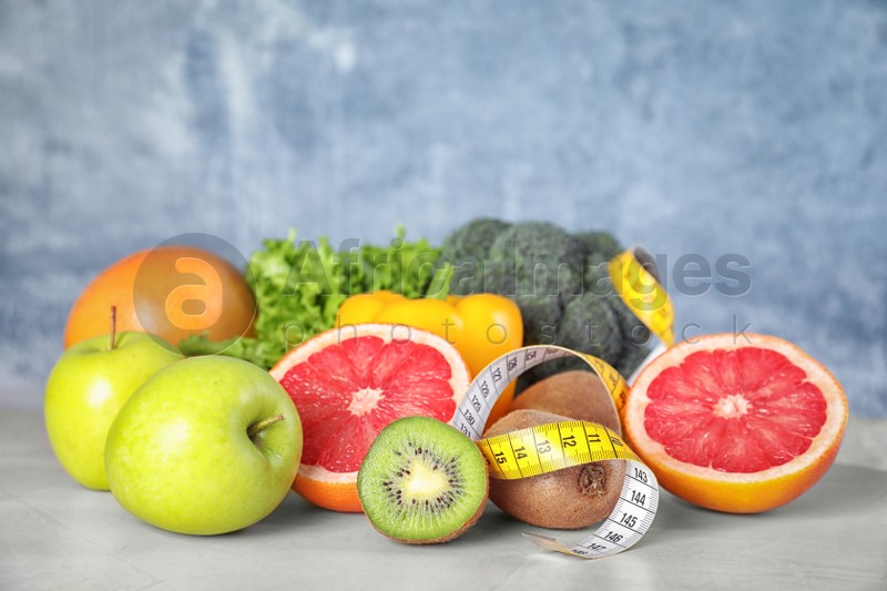 Measuring tape, vegetables and fruits on table. Diet plan from nutritionist
