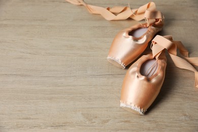 Photo of Ballet shoes. Elegant pointes on wooden floor, space for text