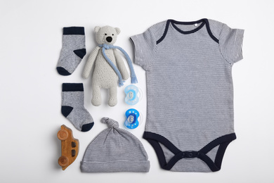 Flat lay composition with child's clothes and toys on white background
