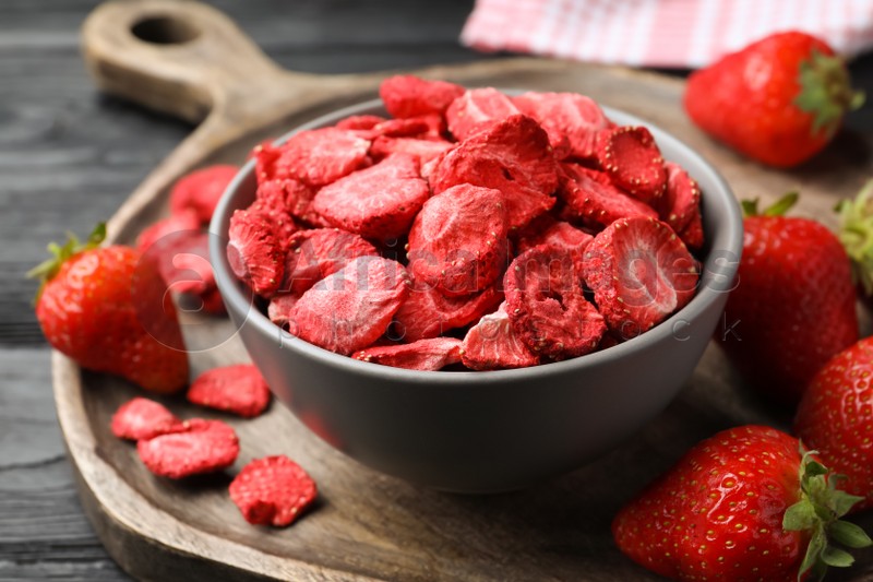 Freeze dried and fresh strawberries on wooden table, closeup