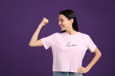 Strong woman as symbol of girl power on purple background. 8 March concept