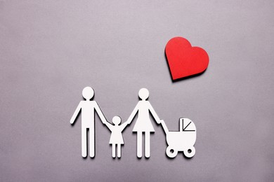Figures of family under heart on lilac background, top view. Insurance concept