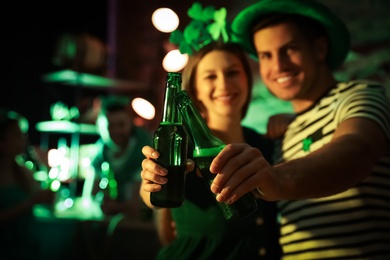 Couple with beer celebrating St Patrick's day in pub, focus on hands