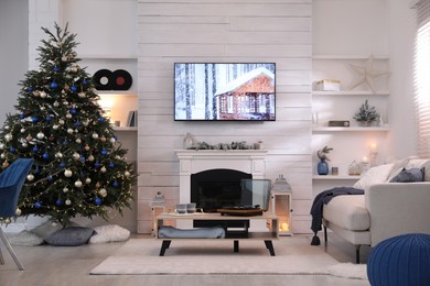 Photo of Stylish living room interior with modern TV, fireplace and Christmas tree