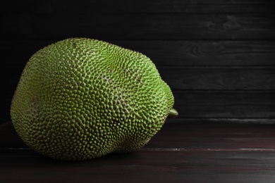 Fresh exotic jackfruit on black wooden table. Space for text