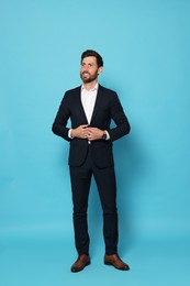Photo of Handsome bearded man in suit looking away on light blue background