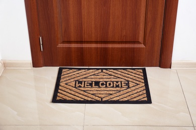 Brown welcome doormat at door in hall