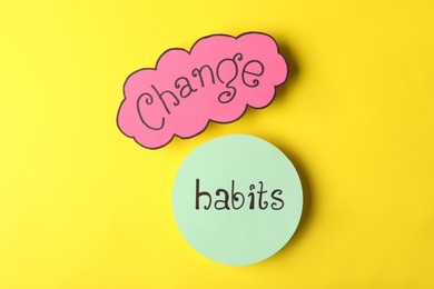 Phrase Change Habits on yellow background, flat lay