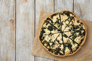 Photo of Delicious homemade spinach quiche on rustic wooden table, top view