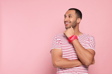 Photo of Portrait of happy African American man on pink background. Space for text
