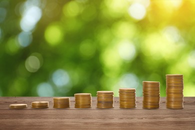 Stacked coins on wooden table against blurred background. Investment concept