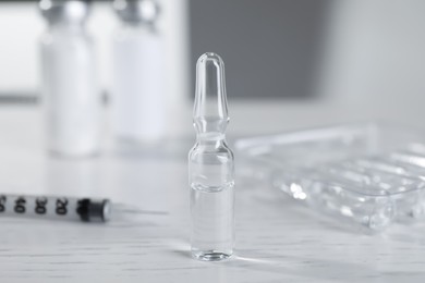 Pharmaceutical ampoule with medication on white wooden table