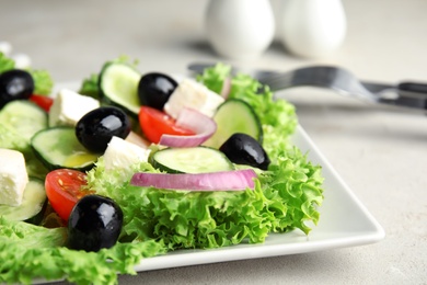 Tasty fresh Greek salad on grey table, closeup