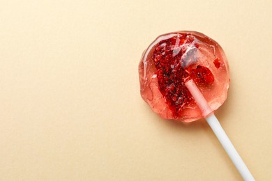 Sweet colorful lollipop with berries on beige background, top view. Space for text