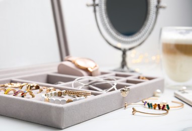 Elegant jewelry box with beautiful bijouterie on white table, closeup
