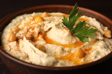 Bowl of tasty hummus with chickpeas and paprika, closeup