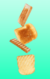 Tasty toasts falling on color background 