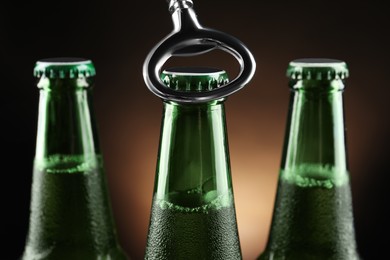 Opening bottle of beer on dark background, closeup