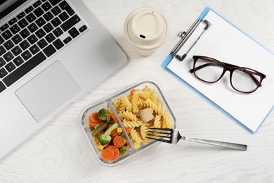 Photo of Container of tasty food, fork, laptop, paper cup of coffee and clipboard on white wooden table, flat lay. Business lunch