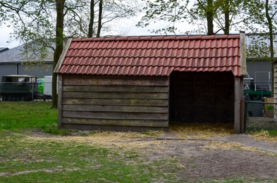 Photo of Wooden animal shed with roof tiles on farm