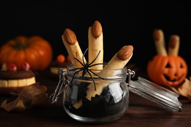 Delicious desserts decorated as monster fingers on wooden table. Halloween treat