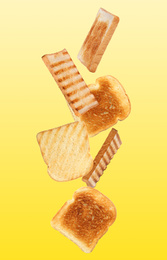 Tasty toasts falling on color background 