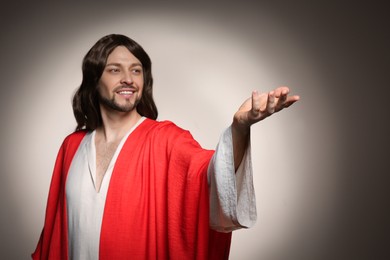 Jesus Christ reaching out his hand on beige background