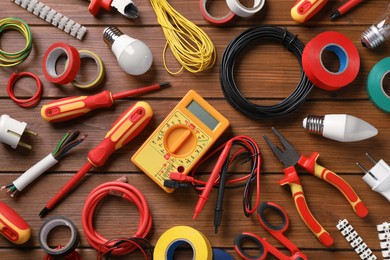 Photo of Flat lay composition with electrician's tools and accessories on wooden background