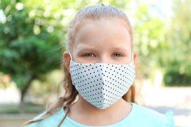 Photo of Preteen girl in protective face mask outdoors