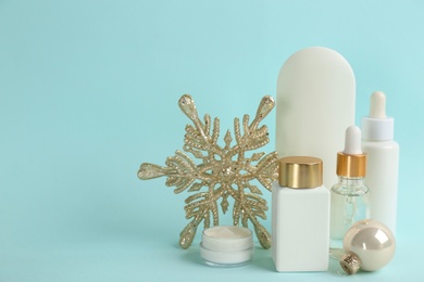 Beautiful composition with cosmetic products on cyan background, space for text. Winter care