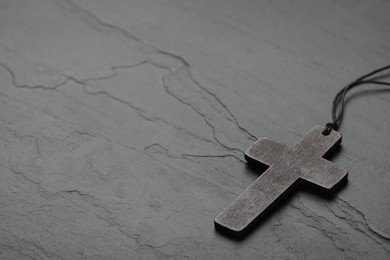 Christian cross on black table, space for text