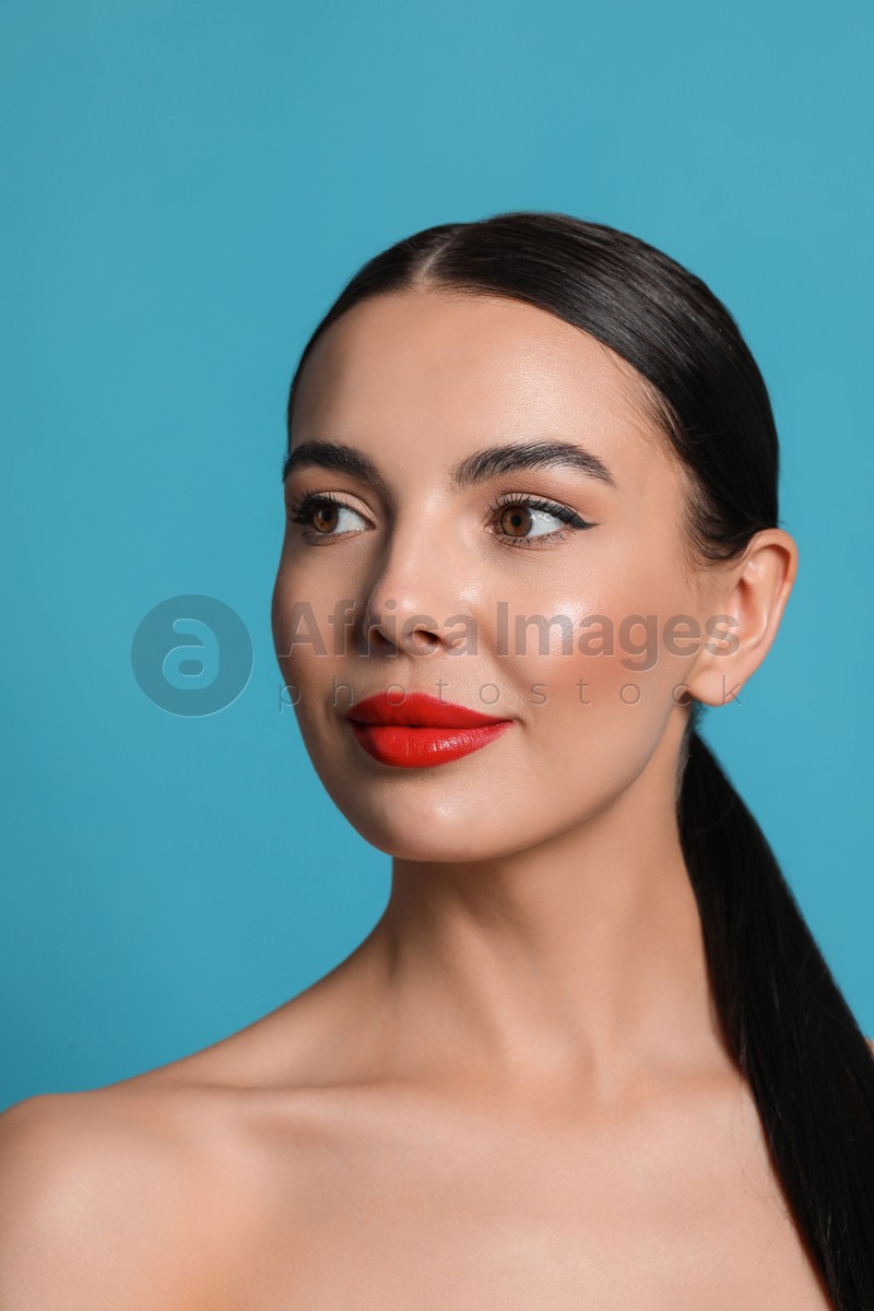 Attractive smiling woman against light blue background