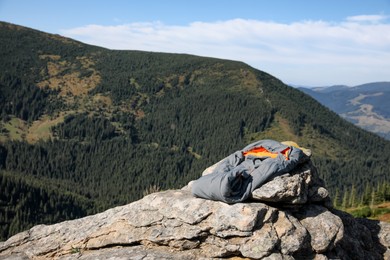 Sleeping bag on mountain peak, space for text